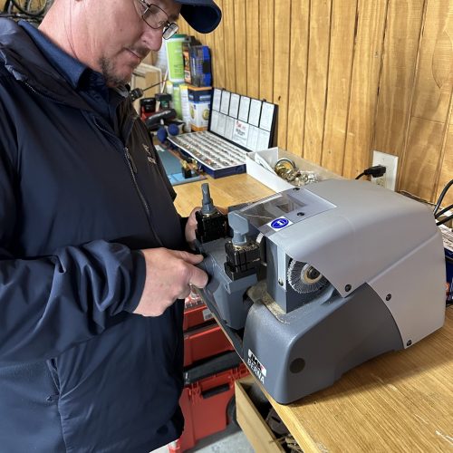 Locksmith in Winchester VA using key cutting machine for precise key duplication at Precision Lock & Key.