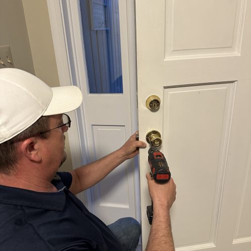 Residential locksmith in Winchester VA installing a secure deadbolt lock on front entry door.